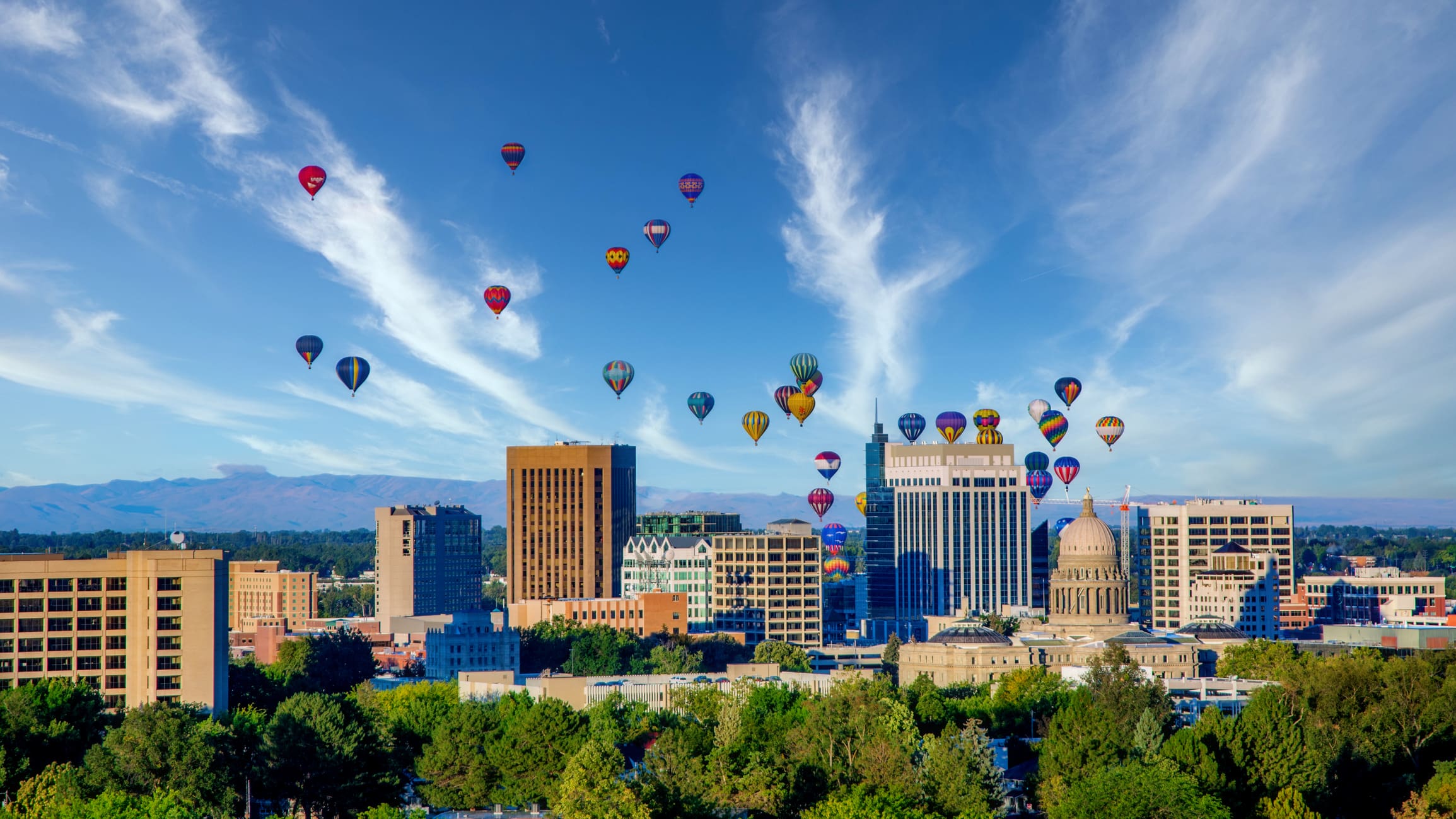 A city with many balloons flying in the air.